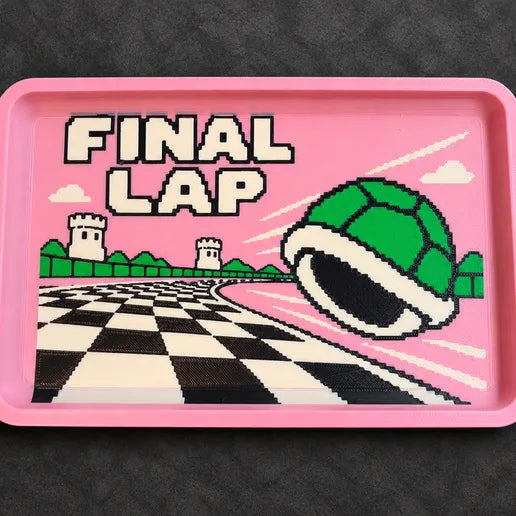 Mario Kart Final Lap desk tray with a green shell and checkerboard track on a pink base
